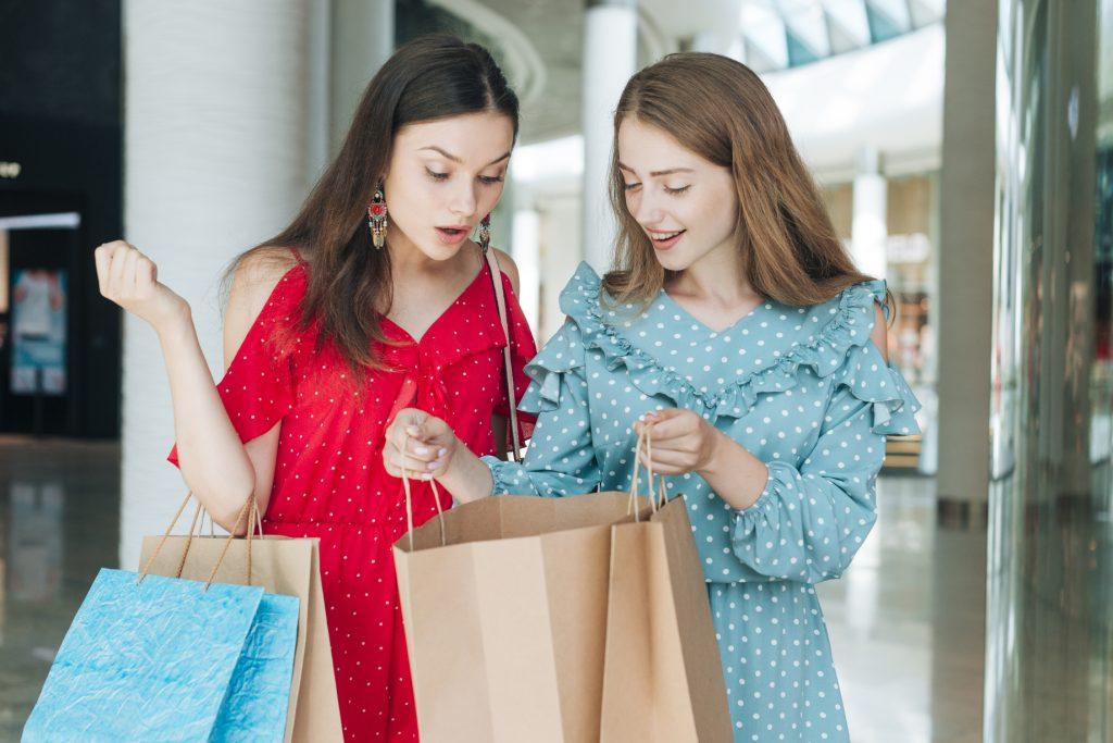 Deux femmes en fin de shopping admirant leur trouvaille.