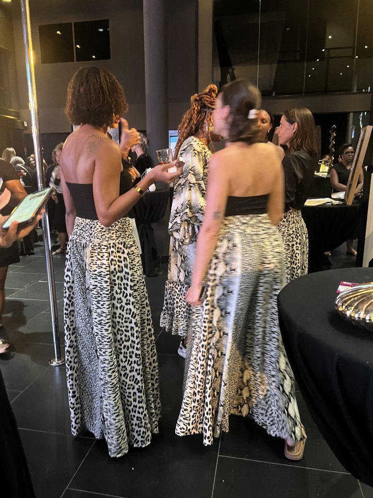 Groupe de femmes en tenues assorties discutant lors de la soirée conviviale et élégante EWAG conscraée aux femmes.